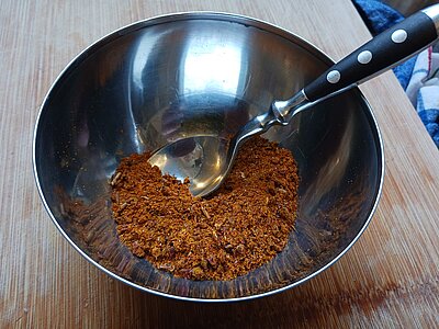 Eine Metallschüssel mit einer Mischung verschiedener Gewürzpulver