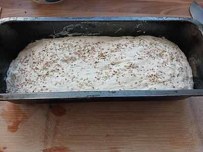 Teig in einer Kastenform, bestreut mit Sesamsamen