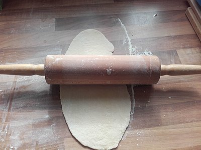 Teig unter einem Nudelholz.
