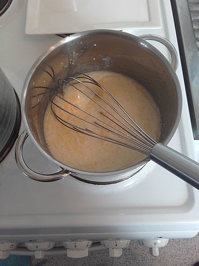 Zerlassene Butter und Mehl in einem Topf mit Quirl.