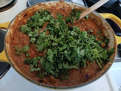 Ein Topf mit Daal Curry und einer Schicht gehacktem Koriander