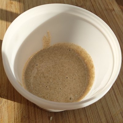 Ein plastikbecher der Sauerteig enthält