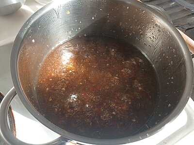 Ein Topf mit brodelnder, braunen Soße