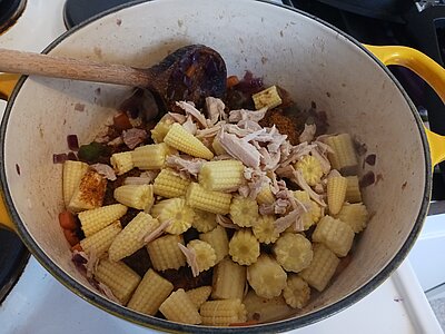 Ein Topf mit einer Schicht aus zerkleinerten Maiskökbchen und klein gezupftem Hühnerfleisch